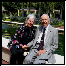 Mrs. Julia Rush sitting with Dr. Richard Rush on the edge of the Garden of Inspiration Koi Pond. 