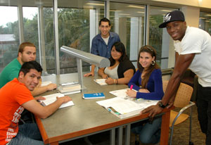 six students in library at a study table